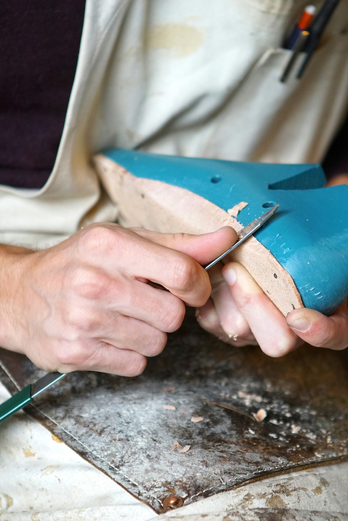 An artisan shaping a shoe by hand