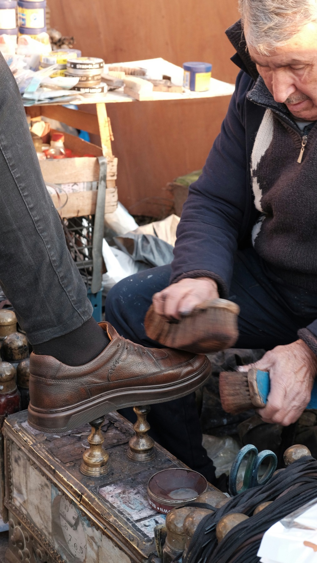 An artisan glazing a shoe by hand in the atelier